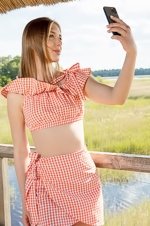 Karianne Bending Over The Railing With A Smile